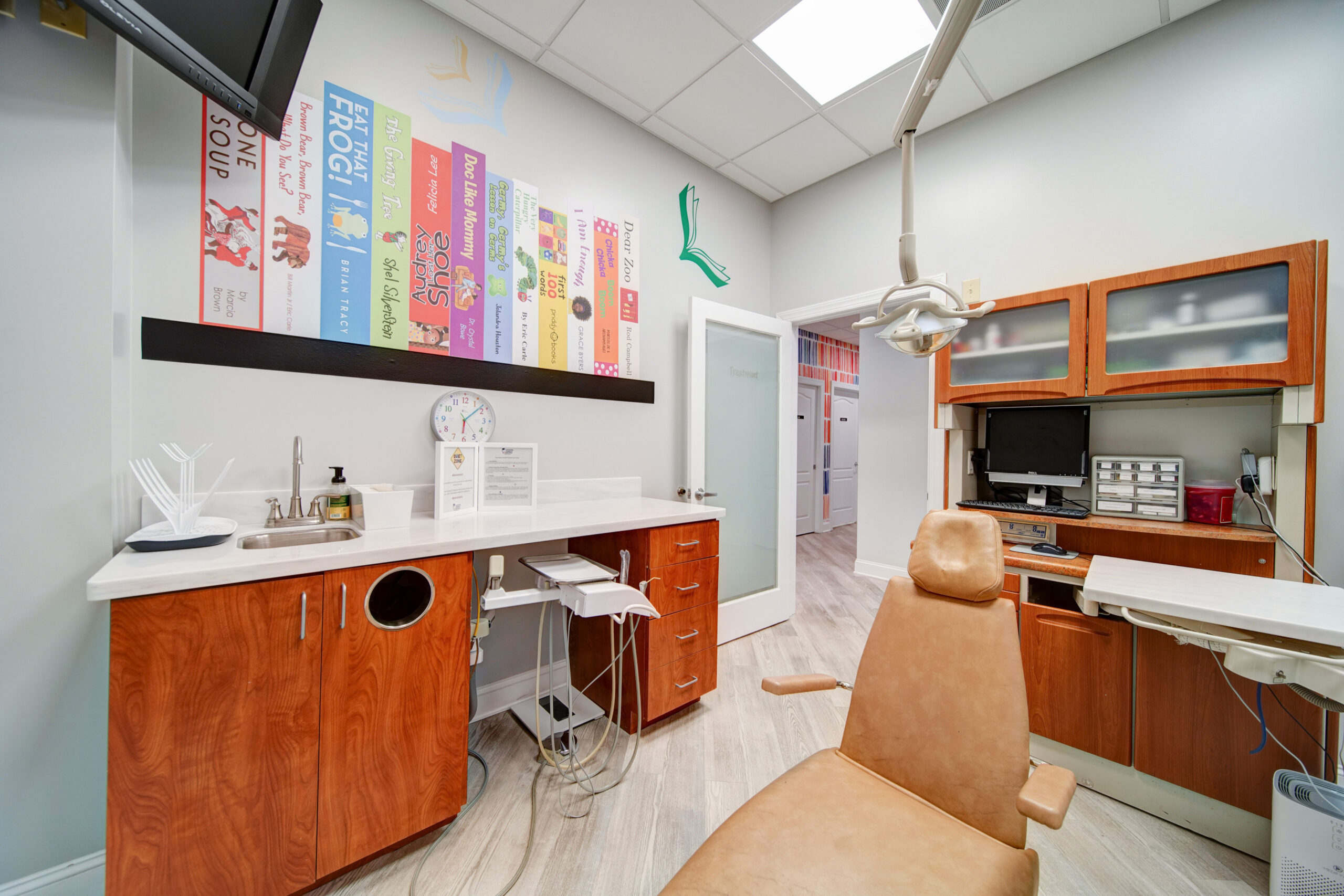 Pediatric dental treatment room with book-themed decor at University Pediatric Dentistry